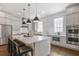Modern kitchen featuring gray cabinets, stainless steel appliances, an island, and pendant lights at 385 Rowes Cir, Alpharetta, GA 30009