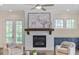 Bright living room with a fireplace, comfortable chairs, and windows letting in plenty of light at 385 Rowes Cir, Alpharetta, GA 30009