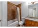 A bathroom with a single vanity, granite countertop, and tub with tile surround at 6177 Idlewood Cir, Lithonia, GA 30038