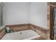 A soaking tub with wood-look surround provides a relaxing space at 6177 Idlewood Cir, Lithonia, GA 30038