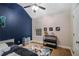 A bedroom with blue accent wall, ceiling fan, and gaming decor at 6177 Idlewood Cir, Lithonia, GA 30038