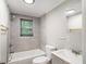 Updated bathroom with tiled shower-tub, toilet, and single sink vanity with grey cabinet at 1186 Eastview Ne Rd, Conyers, GA 30012