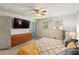 Modern bedroom with a large TV, ceiling fan, and two windows that provide plenty of light at 2839 Orion Dr, Decatur, GA 30033