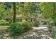 View of a two-story home with a long driveway and carport surrounded by mature trees at 2839 Orion Dr, Decatur, GA 30033