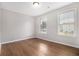 Bedroom featuring light walls, wood flooring and two windows that provide plenty of natural light at 2894 Regent Walk Dr, Duluth, GA 30096