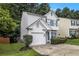 Charming two-story home with white stucco, attached garage, blue shutters, and manicured landscaping at 2894 Regent Walk Dr, Duluth, GA 30096