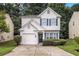 Two-story home featuring white stucco, attached garage, blue shutters, and a well-kept front lawn at 2894 Regent Walk Dr, Duluth, GA 30096