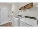 Well-lit laundry room with a washer, dryer, and overhead storage at 3262 Beech Hollow Ct, Loganville, GA 30052