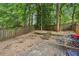 Multi-tiered backyard with patio area, stone landscaping, and wooded views at 1028 Constitution Way, Cumming, GA 30040