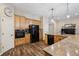 Bright kitchen with wooden cabinets, black appliances and granite countertops at 1028 Constitution Way, Cumming, GA 30040