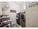 Functional laundry room equipped with modern washer and dryer units and ample storage space at 1028 Constitution Way, Cumming, GA 30040
