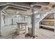 Unfinished basement with exposed ceiling, shelving, and stairs at 1080 Clifton Ne Rd, Atlanta, GA 30307