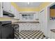 Classic kitchen with white cabinets, black appliances, and black and white checkered floor at 1080 Clifton Ne Rd, Atlanta, GA 30307