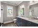 Bathroom with a double vanity with white marble countertops, and a large window at 1338 Iverson Ne St, Atlanta, GA 30307