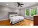 Bedroom with large windows, hardwood floors, modern ceiling fan and a gray tufted headboard at 1338 Iverson Ne St, Atlanta, GA 30307