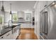 Bright kitchen with stainless appliances, double ovens, white cabinets, and large stainless farm sink at 1338 Iverson Ne St, Atlanta, GA 30307