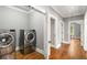 Modern laundry room with stainless steel washer and dryer, hardwood floors, and ample space at 1338 Iverson Ne St, Atlanta, GA 30307
