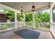 Covered porch with stylish lanterns, wooden floors, and a railing overlooking lush greenery at 1338 Iverson Ne St, Atlanta, GA 30307