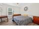 Cozy bedroom with a blue patterned bedspread, wood-look flooring, and natural light from the window at 936 Tyrell Dr, Austell, GA 30106