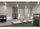 Well-lit kitchen boasts stainless steel appliances, a center island, and crisp white cabinetry at 1026 Cagle Creek Ovlk, Canton, GA 30115