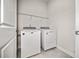 Bright laundry room features a white washer and dryer with an overhead storage shelf at 1026 Cagle Creek Ovlk, Canton, GA 30115