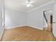 Spacious bedroom with wood flooring, a ceiling fan, and access to a hallway with staircase at 120 Daniel Creek Ln, Sugar Hill, GA 30518
