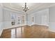 Bright dining room featuring hardwood floors, elegant chandelier, and wainscoting at 120 Daniel Creek Ln, Sugar Hill, GA 30518