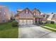 Well-maintained brick home with a two-car garage and a lush green lawn at 120 Daniel Creek Ln, Sugar Hill, GA 30518