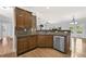 View of the kitchen with stainless steel dishwasher and dark wood cabinets at 120 Daniel Creek Ln, Sugar Hill, GA 30518