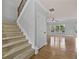 Carpeted staircase leads to a living room with wood floors, lots of light and ceiling fan at 120 Daniel Creek Ln, Sugar Hill, GA 30518