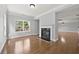 Bright living room featuring a fireplace and shiny hardwood floors at 120 Daniel Creek Ln, Sugar Hill, GA 30518