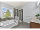 The main bathroom features a separate shower, bathtub, and dual sinks beneath a large window at 120 Daniel Creek Ln, Sugar Hill, GA 30518
