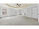 Large primary bedroom with a decorative tray ceiling and open doors to other rooms at 120 Daniel Creek Ln, Sugar Hill, GA 30518