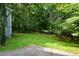 A lush, green backyard with mature trees, providing shade and privacy for outdoor enjoyment and relaxation at 55 Legend Creek Cv, Douglasville, GA 30134
