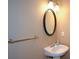 A half bathroom features a pedestal sink, an oval mirror and brushed nickel fixtures at 55 Legend Creek Cv, Douglasville, GA 30134