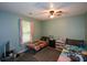 Well-lit bedroom featuring neutral walls, ceiling fan and a window with pink curtains at 55 Legend Creek Cv, Douglasville, GA 30134