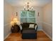 Cozy seating area with chair, ottoman, table lamp, and a large window at 55 Legend Creek Cv, Douglasville, GA 30134