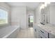 Elegant bathroom with a soaking tub, granite counters, and modern tile flooring at 7532 Milford Pl, Douglasville, GA 30135