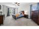 Cozy bedroom with a ceiling fan, plush carpet, and natural light from large windows at 7532 Milford Pl, Douglasville, GA 30135