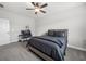 Inviting bedroom featuring soft carpet, bed with dark bedding, a window and a fan at 7532 Milford Pl, Douglasville, GA 30135