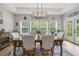 Dining room with large windows, wooden table and chairs, and an elegant light fixture at 7532 Milford Pl, Douglasville, GA 30135