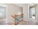 Carpeted hallway with natural wood banister leading to bedrooms and the main living area at 233 Hampton Station Blvd, Canton, GA 30115