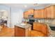 Well-lit kitchen featuring granite countertops, a practical island, and stainless steel appliances with wood cabinetry at 233 Hampton Station Blvd, Canton, GA 30115