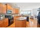 Spacious kitchen with granite countertops, stainless steel appliances, and a functional center island with wooden cabinets at 233 Hampton Station Blvd, Canton, GA 30115