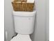 A close-up of a clean, white toilet with a decorative wicker basket on top at 233 Hampton Station Blvd, Canton, GA 30115