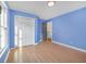 Light-filled blue bedroom features hardwood floors, a window, and a double door closet at 358 Woodbrook Crst, Canton, GA 30114