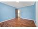 Spacious blue bedroom with wood floors and a gray door with white trim at 358 Woodbrook Crst, Canton, GA 30114