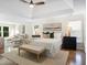 Primary bedroom featuring hardwood floors, seating, and large bed with a tray ceiling at 358 Woodbrook Crst, Canton, GA 30114