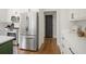 Kitchen area showcases stainless steel refrigerator, white cabinets with black hardware, and hardwood floors at 358 Woodbrook Crst, Canton, GA 30114