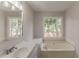 Neutral-toned bathroom features large soaking tub, and lots of natural light from large window at 3614 Spring Leaf Ln, Acworth, GA 30101